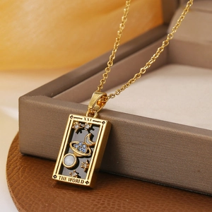 Macro detail of gold tarot pendant featuring The World design with blue zircon inlay