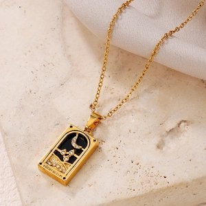 Detailed macro of gold Knight of Cups tarot pendant with black enamel and moon design