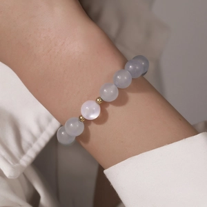 Detailopname van 8mm blauwgrijze kristallen kralenarmband met gouden tussenstukjes