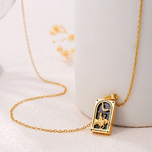 Macro shot of gold tarot necklace pendant featuring Knight of Cups on black enamel