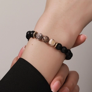 Pulsera artesanal de piedra volcánica para hombre con cuentas negras mate y mármol veteado