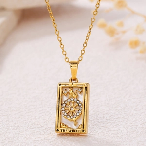 Macro shot of gold tarot pendant with Wheel of Fortune design and zircon stones