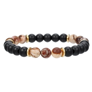 Primer plano detallado de pulsera artesanal de piedra volcánica con cuentas negras mate