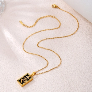 Detail of gold tarot Magician pendant with zircons and S925 clasp on a textured surface