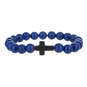 Detail van blauwe natuursteen kralen en matzwarte kruis hanger op een heren armband