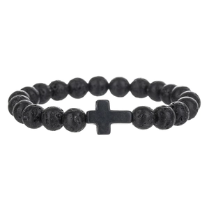 Detailopname van poreuze zwarte lavasteenkralen en matte kruisbedel op de armband