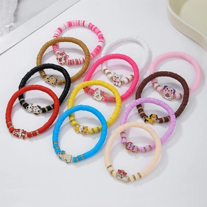 Detail von bunten Polymer-Ton-Armbändern mit Cartoon-Hundeanhängern und Kristallperlen