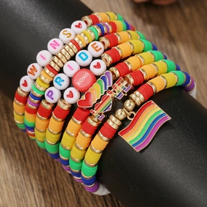 Close-up of colorful polymer clay bead bracelets with Pride charms and letter beads
