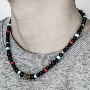 Détail du collier de perles ethniques avec pierre de lave et perle dorée filigranée
