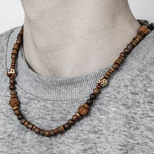Detail of bohemian wood bead necklace featuring brown coconut shell beads and ethnic patterns