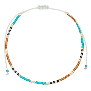 Detail van bohemien kralenarmband met turquoise en gouden kralen op wit koord