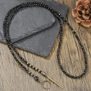 Boheemse gothic lange ketting met zwarte kralen en bronzen klinknagel hanger detail