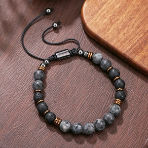 Detail van een kralenarmband van lavasteen met een verstelbaar gevlochten koord