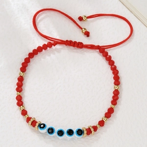 Detail van rode kralenarmband met boze oog bedeltjes en verstelbaar trekkoord