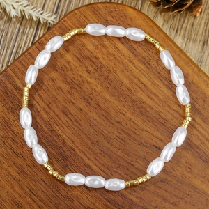 Detail van elegante witte ovale parels en gouden afstandhouders op een houten dienblad