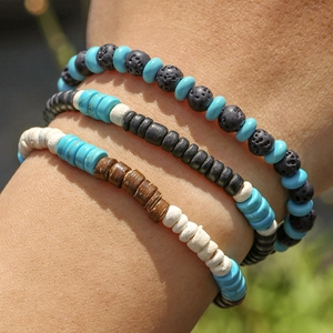 Detail van meerlaagse kralenarmband met lavasteen, turquoise en houten kralen om pols