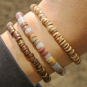 Detail of stacked bohemian wood beads and marble natural stone bracelets for men