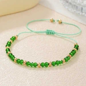 Detail van een handgeweven groene kristallen kralenarmband met verstelbaar nylon koord