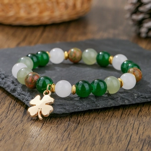 Detalle de la pulsera de cuentas multicolor con piedras verdes y colgante de trébol