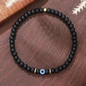 Detail van 6mm zwarte agaat kralenarmband met blauw boze oog en goudkleurige accenten