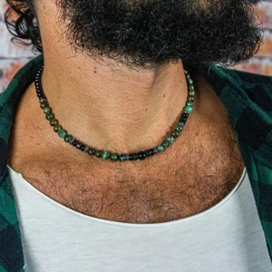 Close-up of men's beaded necklace with green mineral stones and engraved silver spacers