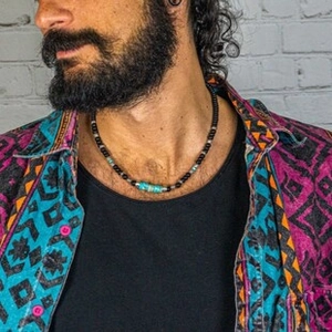 Detailed view of men's colorful bead necklace with turquoise and black accents on model