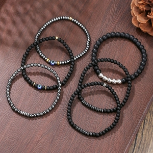 6mm zwarte onyx kralenarmbanden met blauwe boze oog bedels op een houten achtergrond
