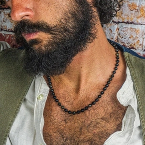 Close-up of 6mm black obsidian bead necklace worn by male model for vintage style