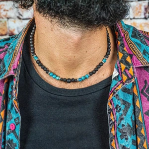 Detail of men's bohemian necklace with matte black beads and turquoise stone accents