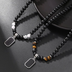 Macro view of beaded necklaces featuring tiger eye stones and silver rectangular pendants