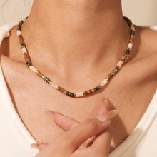 Detail van meerkleurige etnische kralenketting met natuursteen textuur op een mannelijk model