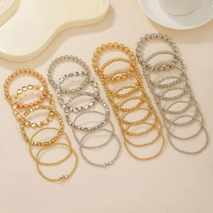 Perlenarmband-Set mit Sternanhängern in Gold und Silber auf elegantem Hintergrund