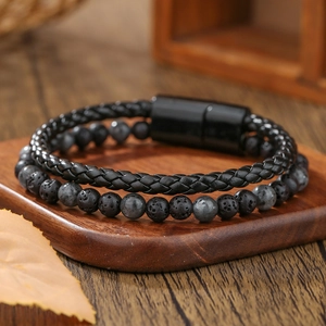 Detalle de pulsera para hombre en cuero trenzado con cuentas de lava y cierre magnético negro