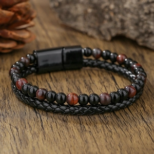 Detalle de pulsera de cuero para hombre con cuentas negras y ojo de tigre sobre madera