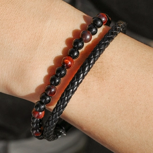 Detalle de pulsera de cuero trenzado con cuentas de ágata negra y ojo de tigre para hombre