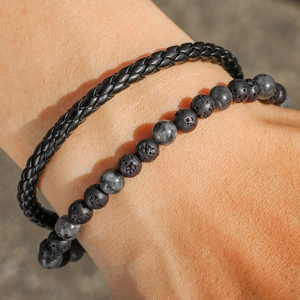 Detalle de pulsera de cuero trenzado para hombre con piedras de lava negra y ojo de tigre