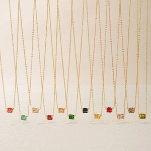Collana delicata placcata in oro con ciondoli cilindrici in zircone colorato in varie tinte