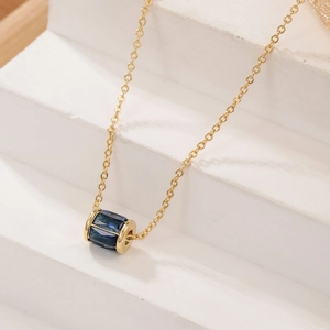 Dettaglio della collana con pendente a cilindro placcato oro e zircone blu lucido