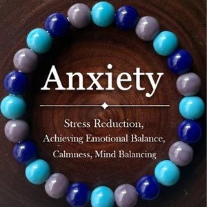 Stress relief gemstone bracelet with blue and purple beads on wooden background