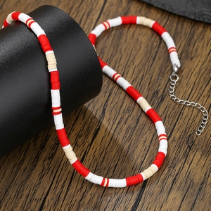 Detail of colorful heishi bead necklace with red and white clay discs and lobster clasp