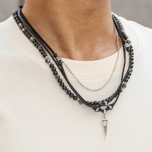Detail van gelaagde lederen ketting met zwarte onyx kralen en een vintage tribal hanger