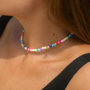 Colorful polymer clay Heishi bead choker necklace worn by a model for a beach look