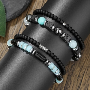Primo piano di bracciali con pietra lavica nera e perle turchesi su supporto