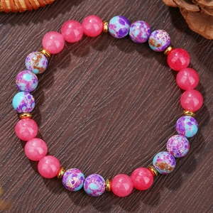 Handgemaakte stretcharmband met roze harskralen en blauwe marmeren stenen op hout