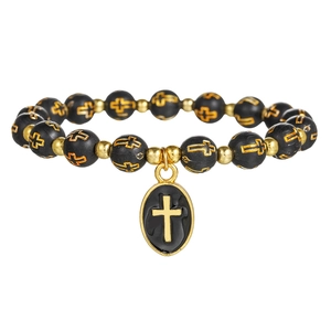 Pulsera religiosa con cuentas negras mate, cruces doradas y colgante de crucifijo ovalado
