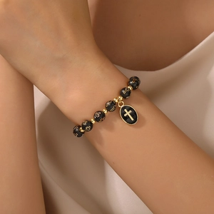 Pulsera religiosa de cuentas negras con cruces doradas y un amuleto de cruz ovalada