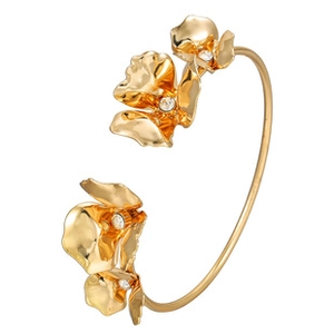 Detailed macro view of an open gold floral bracelet featuring polished metal petals and zircons