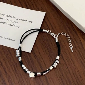 Close-up of double-strand black cord bracelet with silver geometric beads and lobster clasp
