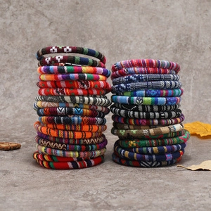 Macro view of woven ethnic style ceramic fish beads on a durable multi-color fabric cord