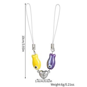 Detailed view of yellow and purple ceramic fish charms with magnetic heart connector